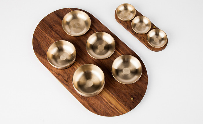 Walnut tray of brass tableware